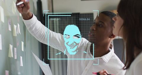 Business Team Writing on Wall with Digital Face Recognition Overlay