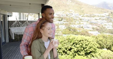 Happy Couple Enjoying Scenic Hillside View on Balcony