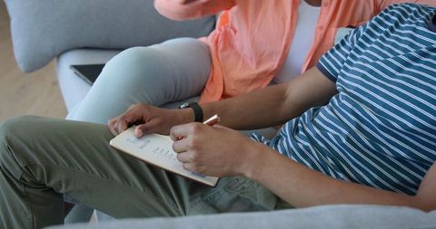 Couple Relaxing on Sofa Exploring Tablet Apps in Cosy Living Room