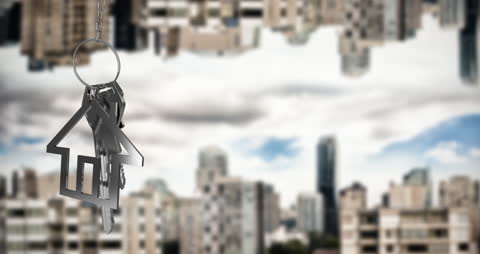 Silver House Keychain Over Blurred Cityscape Background