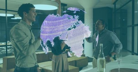 Team collaborating around purple hologram globe in modern office lounge for global strategy