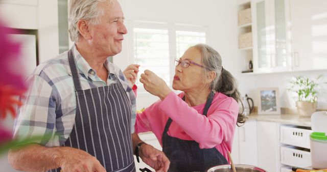 Happy Elderly Couple Cooking and Tasting Food Together - Download Free Stock Images Pikwizard.com