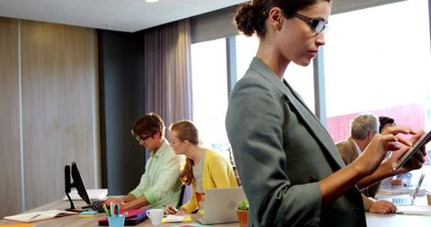 Professional Woman Using Tablet in Collaborative Meeting Room