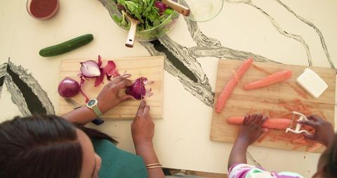 African american mother and child cooking chopping onion peeling carrots home meal prep