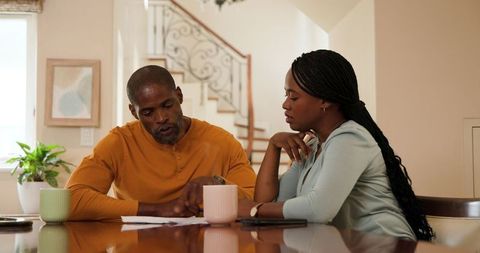 Mature Couple Discussing Home Finances at Kitchen Table