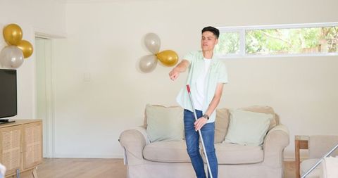 Young Man Joyfully Dancing in Living Room during Celebration