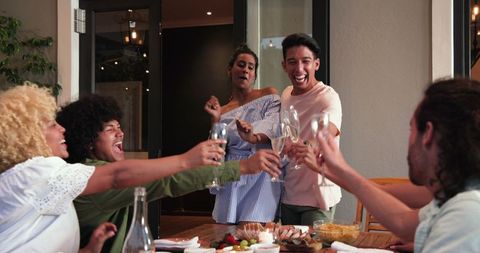 Joyful Diverse Group Cheers at a Celebration Dinner