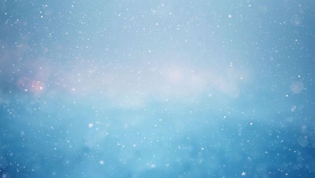 Soft blue winter background with falling snowflakes, bokeh and gentle lens flare