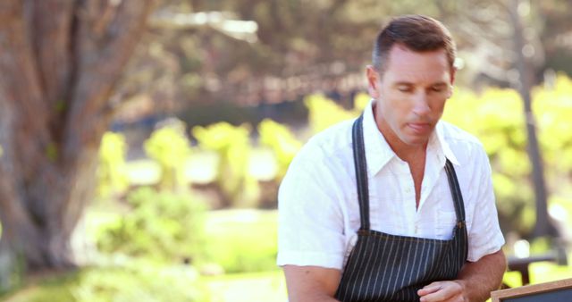 Male Chef Cooking Outdoors Wearing Apron and White Shirt - Download Free Stock Images Pikwizard.com