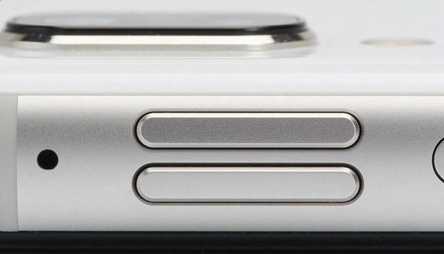 Close-up smartphone edge showcasing pill volume buttons and camera ring on aluminum frame