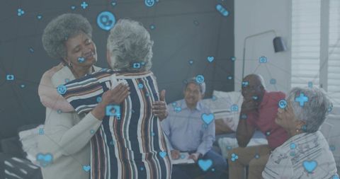 Senior women hugging in cozy living room showing digital health icons overlay