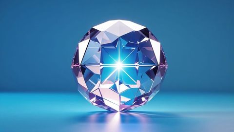 Faceted crystal sphere reflects starburst light on glossy surface