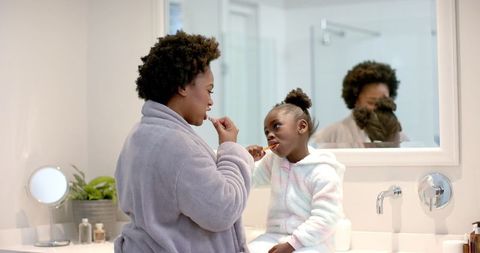 Mother and Daughter Brushing Teeth Bonding Moment in Bathroom