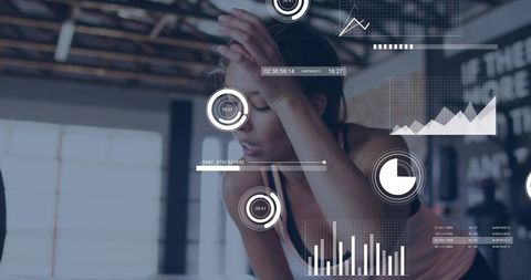 Female Athlete Leaning and Catching Breath in Gym with Fitness Analytics Overlay