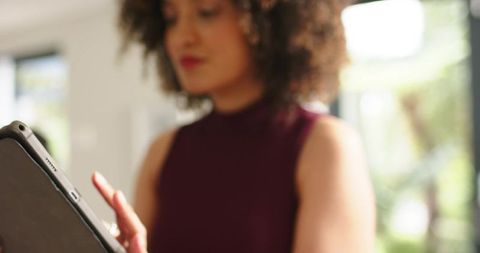 African american woman using tablet at home touchscreen productivity in natural light