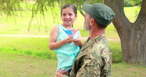 Heartwarming Reunion Between Soldier and Child Holding American Flag