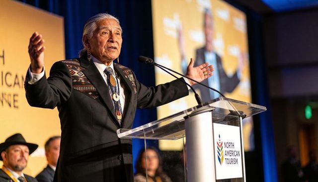 Keynote speaker at north american tourism conference wearing beaded medallion