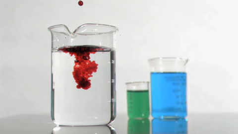 Red Droplets Falling into Water in Laboratory