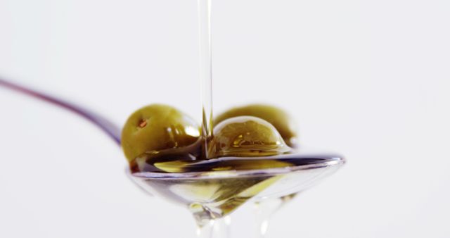 Close-Up of Olive Oil Pouring Over Green Olives on Spoon - Download Free Stock Images Pikwizard.com