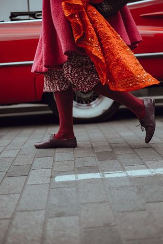 Fashionable Woman Passing Vintage Red Car