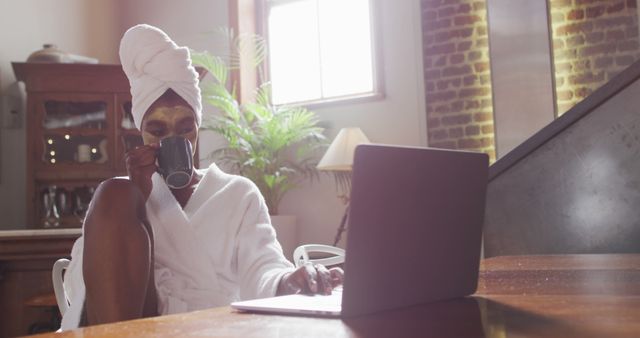 Relaxed Woman Drinking Coffee in Robe While Working on Laptop at Home - Download Free Stock Images Pikwizard.com