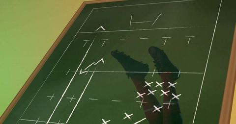 Coach chalkboard showing soccer tactics with player legs and cleats silhouette