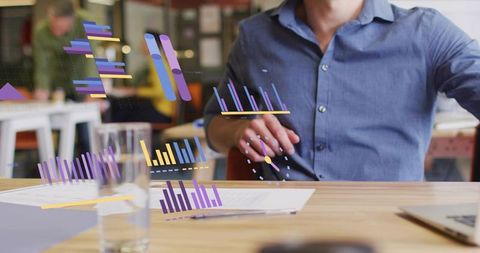 Businessman interacting with virtual data charts at office desk