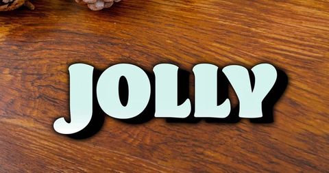 Jolly pale blue cutout letters on rustic wood tabletop with pinecones holiday decor