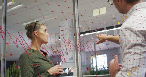 Business Team Analyzing Financial Graph on Glass Wall