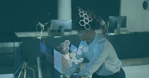 It specialist adjusting monitor in futuristic office with ar hexagon interface overlay