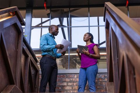 Coworkers Collaborating on Modern Industrial Office Staircase
