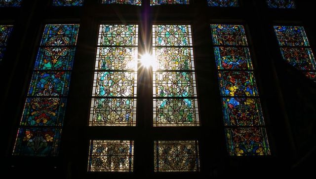 Vibrant stained glass windows with sunburst in church