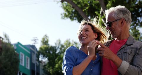Smiling Mature Couple Embracing Outdoors on Sunny Day