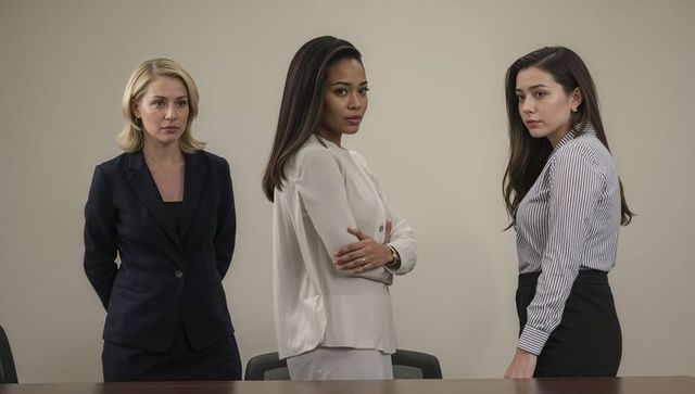 Three confident businesswomen standing displaying serious expressions corporate teamwork