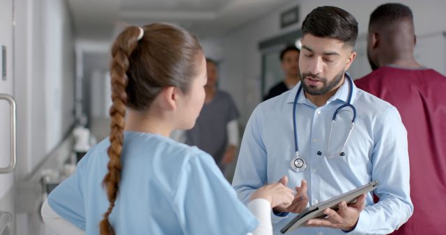 Healthcare Professionals Discussing Patient Information in Hospital Corridor - Download Free Stock Images Pikwizard.com