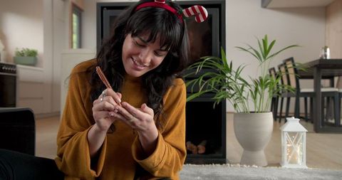 Woman Celebrating Holidays Relaxing by Fireplace