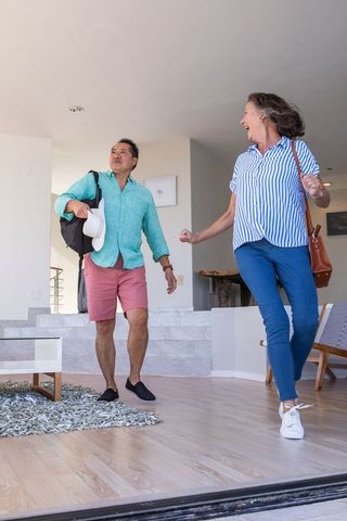 Happy Mature Couple Entering Modern Home for Travel Relaxation