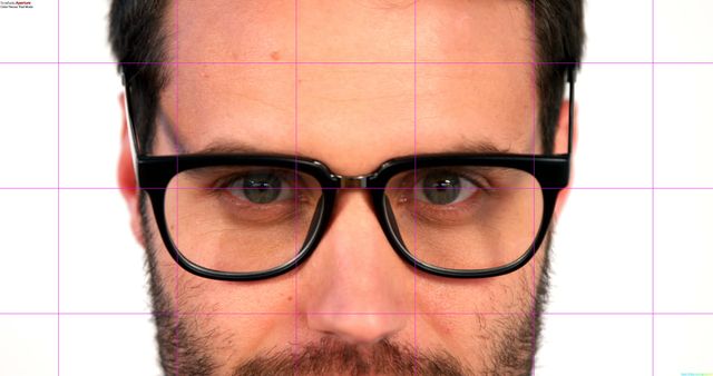 This image captures a close-up view of a man's face, highlighting his black eyeglasses and beard. The man appears focused and serious against a white background. Ideal for use in advertisements for eyewear, fashion editorials, graphic design projects, and profiles. It can also be used in articles or blog posts discussing men's fashion or eyewear trends.