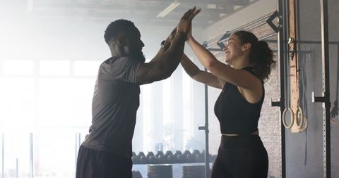 Diverse Fitness Partners Celebrating Achievement in Gym