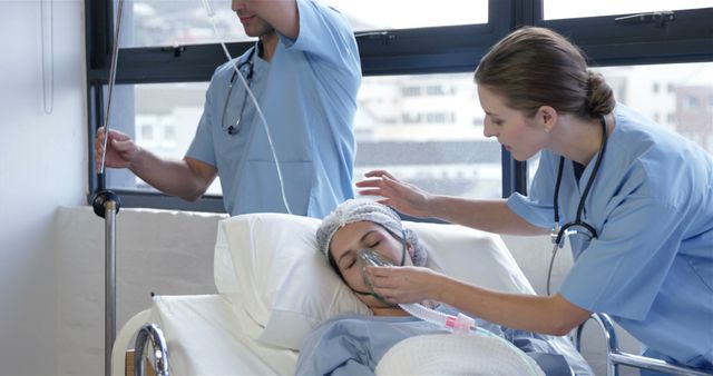 Medical professionals, including a nurse and a doctor, provide care to a patient in a hospital bed. The nurse adjusts an oxygen mask on the patient while the doctor attends to an IV. Suitable for use in healthcare, medical service promotions, team cooperation, or patient recovery contexts.