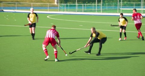 Intense field hockey match on green artificial turf