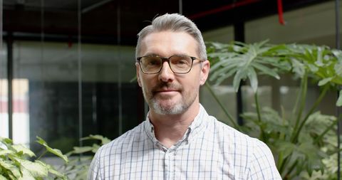 Confident businessman smiling in modern office plot