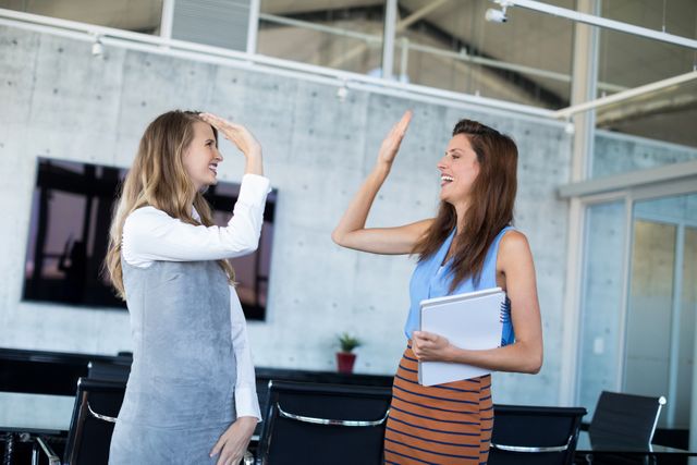 Female executives giving high five in office