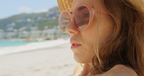 Woman with Sunglasses Relaxing on Sunny Beachfront - Download Free Stock Images Pikwizard.com