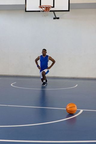 Basketball Player Stretching in Gym for Workout Routine