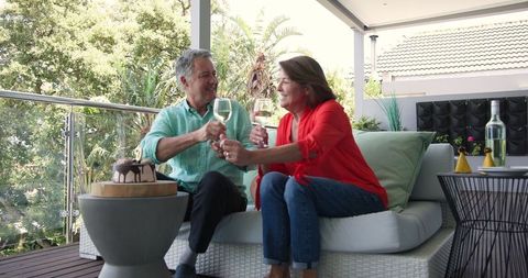 Senior couple enjoying wine and cake on outdoor patio