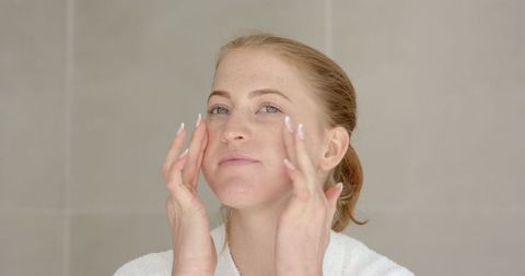 Woman Gently Applying Facial Cream for Skincare Routine