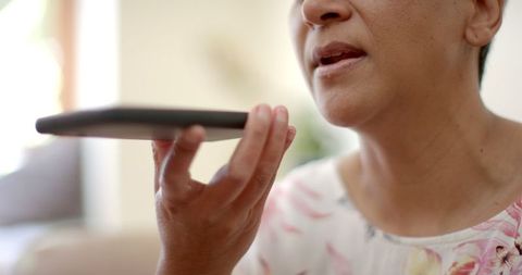 Senior Woman Using Smartphone Voice Command Comfortably at Home