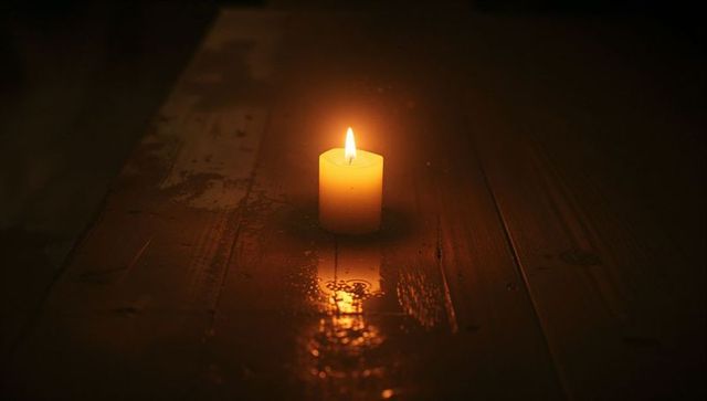 Tranquil Glow of Candlelight on Wooden Surface in Dark Room