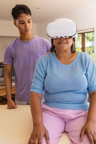 Senior Woman Using VR Headset with Grandson in Living Room